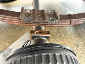 4. With the bolts removed, drop the floor jack to create space between the axle and the spring.