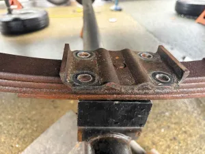 7. Raise the jack and position the new tie plate on top of the spring.