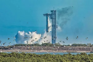 The booster returns to the launch site and is secured by mechanical "chopsticks."