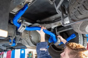 A technician installs a SuperSteer sway bar on a Mercedes-Benz Spinter 3500 van.